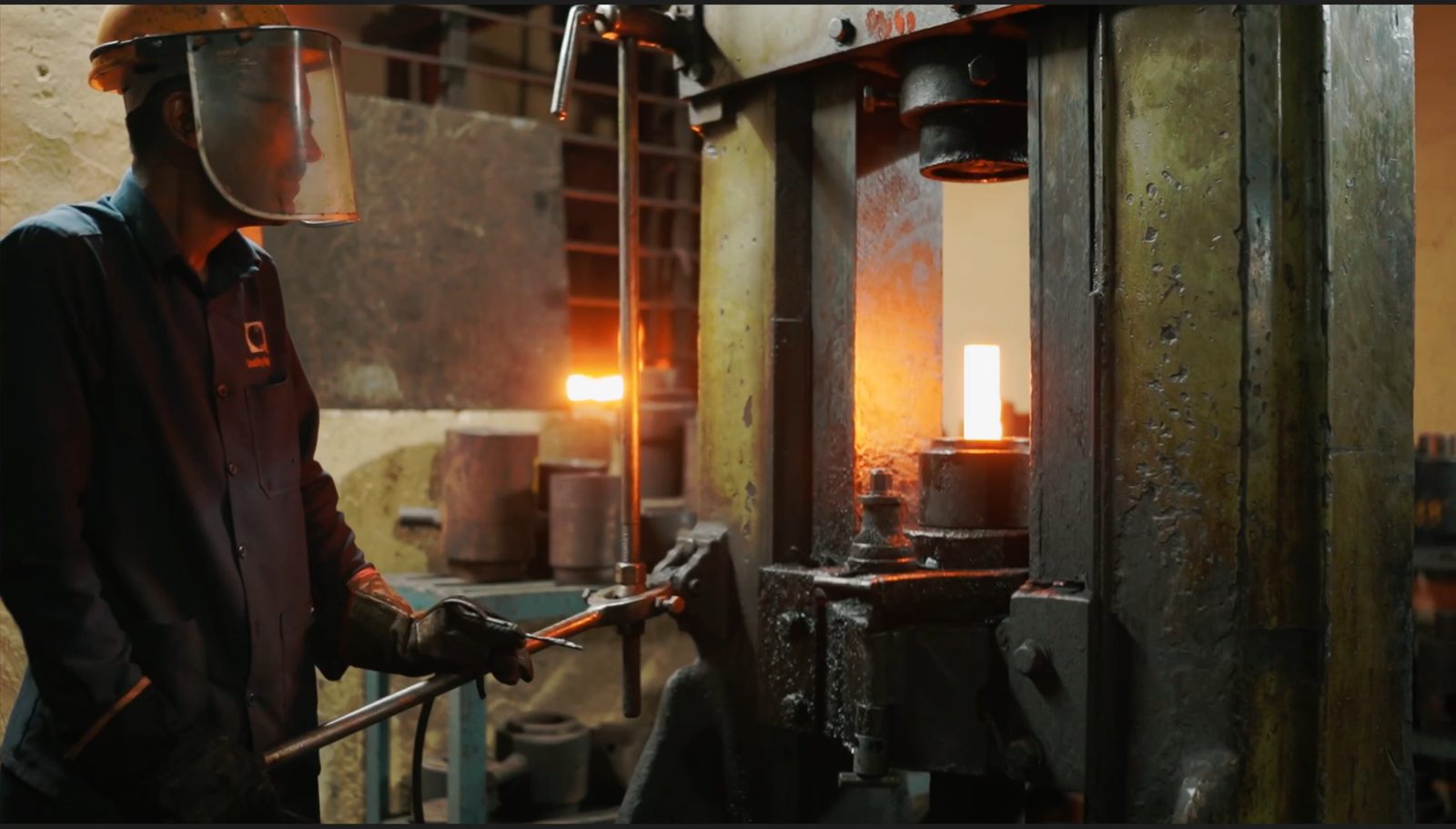 Forge worker shaping a heated component